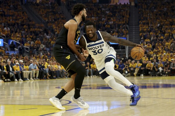 Minnesota Timberwolves forward Julius Randle (30) drives to the basket against Golden State Warriors forward Trayce Jackson-Davis, left, during the first half of Game 4 in the Western Conference semifinals of the NBA basketball playoffs Monday, May 12, 2025, in San Francisco. (AP Photo/Jed Jacobsohn)