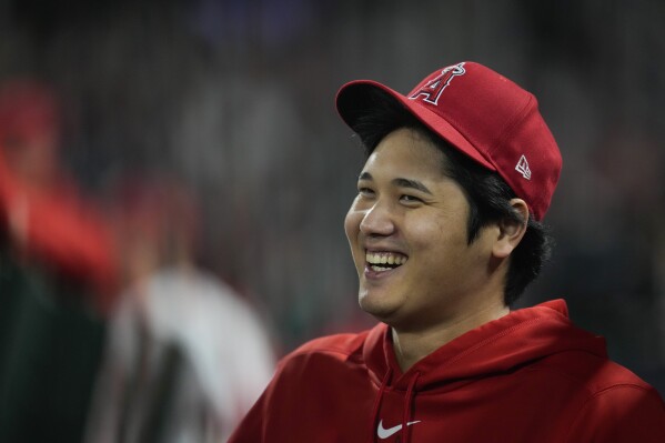 Los Angeles Angels' Shohei Ohtani laughs in the dugout during the ninth inning of a baseball game against the Detroit Tigers in Anaheim, Calif., Saturday, Sept. 16, 2023. (AP Photo/Ashley Landis)