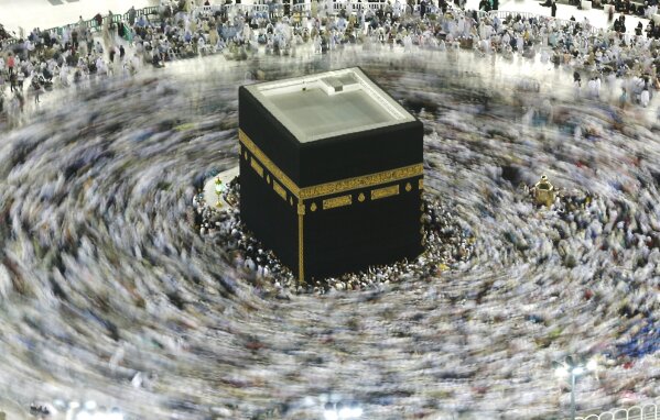 In this picture taken with a slow shutter speed, far smaller crowds than usual of Muslim pilgrims circumambulate the Kaaba, the cubic building at the Grand Mosque, in the Muslim holy city of Mecca, Saudi Arabia, Wednesday, March 4, 2020. The coronavirus outbreak disrupted Islamic worship in the Middle East as Saudi Arabia on Wednesday banned its citizens and other residents of the kingdom from performing the pilgrimage in Mecca, while Iran canceled Friday prayers in major cities. (AP Photo/Amr Nabil)