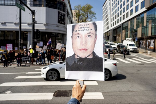 A protester holds a sign against Tesla CEO Elon Musk while rallying outside a Tesla store in San Francisco on Saturday, March 29, 2025. (AP Photo/Noah Berger)