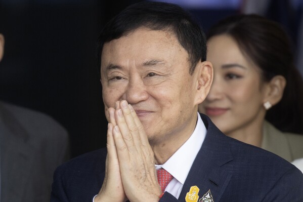 Thailand's former Prime Minister Thaksin Shinawatra greets his supporters as he arrives at Don Muang airport in Bangkok, Thailand, Tuesday, Aug. 22, 2023. (AP Photo/Wason Wanichakorn)