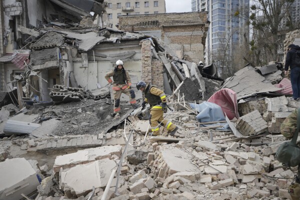 First response officers inspect the damage after a Russian air attack in Kyiv, Ukraine, Monday March 25, 2024. Five people were injured in the strike at Pechersk district of Kyiv, two were hospitalised.(AP Photo/Vadim Ghirda)