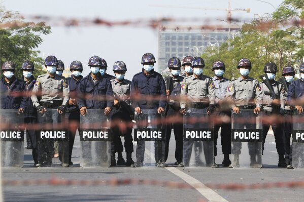 Police officers stand in a road blocking protesters during a demonstration in Mandalay, Myanmar, Tuesday, Feb. 9, 2021. Protesters continued to gather Tuesday morning in major cities breaching Myanmar's new military rulers ban of public gathering of five or more issued on Monday intended to crack down on peaceful public protests opposing their takeover. (AP Photo)