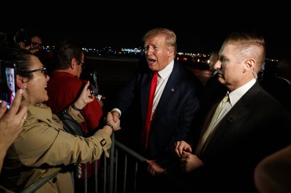 President Donald Trump shakes hands with supporters after arriving at Miami International Airport in Miami, following his re-election kickoff rally in Orlando, Fla., Tuesday, June 18, 2019. (AP Photo/Evan Vucci)