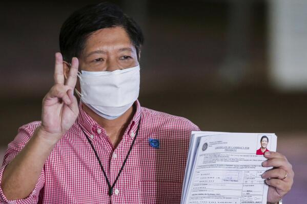 Former senator Ferdinand "Bongbong" Marcos Jr. poses after filing his certificate of candidacy for next year's presidential elections with the Commission on Elections at the Sofitel Harbor Garden Tent in Manila, Philippines Wednesday, Oct. 6, 2021. The son and namesake of the late Philippine dictator Ferdinand Marcos, who was toppled in a 1986 revolt, announced Tuesday that he would seek the presidency in next year's elections in what activists say is an attempt to whitewash a dark period in the country's history marked by plunder and human rights atrocities. (Rouelle Umali/Pool Photo via AP)