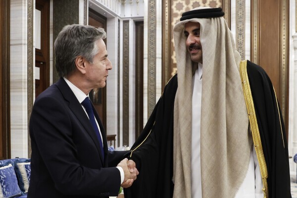 U.S. Secretary of State Antony Blinken, left, shakes hands with Qatar's Emir Sheikh Tamim Bin Hamad Al Thani, during Blinken's week-long trip aimed at calming tensions across the Middle East, at Lusail Palace in Lusail, Qatar, Sunday, Jan. 7, 2024. (Evelyn Hockstein/Pool photo via AP)