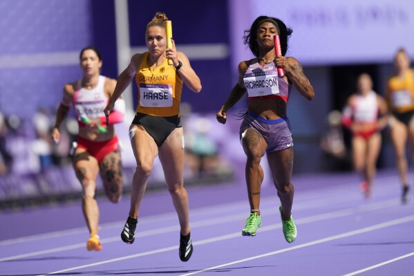Sha'carri Richardson, right, of the United States, and Rebekka Haase, of Germany, in the women's 4x100-meter relay heat at the 2024 Summer Olympics, Thursday, Aug. 8, 2024, in Saint-Denis, France. (AP Photo/Petr David Josek)