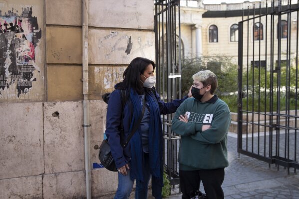 Matteo Coccimiglio talks with Sonia Mugello, a teacher at the Ripetta art Schools in Rome, Wednesday, March 24, 2021. Matteo is an 18-year-old student who identifies as a man and is in the process of changing his legal gender from female to male. The Ripetta school of art in Rome - where he studies - recently joined a handful of high schools in Italy that give transgender students the right to be known by a name other than the one they were given at birth. The initiative is meant to create an environment where transgender students feel secure and reflects a growing awareness in Italy of gender dysphoria among teenagers and children.  (AP Photo/Alessandra Tarantino)