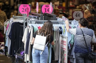 FILE - People looking for cheap clothes in Gelsenkirchen, Germany, on Sept. 28, 2023. The inflation that has been wearing on European consumers fell sharply to 2.9% in October, its lowest in more than two years as fuel prices fell and rapid interest rate hikes from the European Central Bank took hold. (AP Photo/Martin Meissner, File)