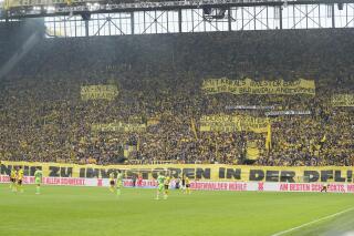 Dortmund supporters display anti-investors banners during the German Bundesliga soccer match between Borussia Dortmund and VfL Wolfsburg in Dortmund, Germany, Saturday, May 7, 2023. (AP Photo/Martin Meissner)
