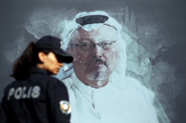 FILE - A Turkish police officer walks past a picture of slain Saudi journalist Jamal Khashoggi prior to a ceremony, near the Saudi Arabia consulate in Istanbul, Oct. 2, 2019. A Dubai-based broadcaster cut substantial portions of a recent episode of the satiric news program "Last Week Tonight with John Oliver" over references to Saudi Arabia's crown prince being implicated in the 2018 killing of Washington Post columnist Jamal Khashoggi. (AP Photo/Lefteris Pitarakis, File)