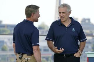 FILE - Seattle Kraken coach Dave Hakstol, left, talks with general manager Ron Francis on July 21, 2021, during the team's NHL hockey expansion draft event in Seattle. The team signed general manager Francis to a three-year contract extension through the 2026-27 season after the franchise reached the second round of the NHL playoffs in its second year of existence. (AP Photo/Ted S. Warren, File)