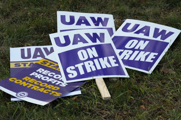 FILE - United Auto Workers signs for a strike are shown at the Stellantis Sterling Heights Assembly Plant, in Sterling Heights, Mich., Monday, Oct. 23, 2023. Jeep maker Stellantis has reached a tentative contract agreement with the United Auto Workers union that follows a template set earlier this week by Ford, two people with knowledge of the negotiations said Saturday, Oct. 28, 2023. (AP Photo/Paul Sancya, File)