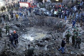 FILE - Rescue workers and soldiers stand around a massive crater after a bomb attack that tore through the motorcade of former Prime Minister Rafik Hariri in Beirut, Lebanon, Feb. 14, 2005. On Thursday, March 10, 2022, the five-judge appeals panel at the Special Tribunal for Lebanon overturned acquittals of two members of the Lebanese militant Hezbollah group in the 2005 assassination of Hariri. The unanimous appeals decision convicting the two said that judges in the original trial verdict committed errors of law and fact leading to a miscarriage of justice. (AP Photo, File)