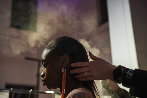 A model gets her hair sprayed backstage for Niger's designer Alia Bare's show during Johannesburg Fashion Week 2023 in Johannesburg, South Africa, Thursday, Nov. 9, 2023. (AP Photo/Jerome Delay)