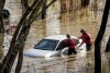 Search and rescue workers investigate a car surrounded by floodwater as heavy rains caused the Guadalupe River to swell, Sunday, Feb. 4, 2024, in San Jose, Calif. The vehicle was uninhabited. (AP Photo/Noah Berger)