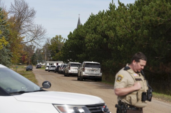 A Benton County sheriff establishes a security perimeter at the intersection of 186th Avenue NE and Glendorado Road NE near Princeton, Minn., following a 