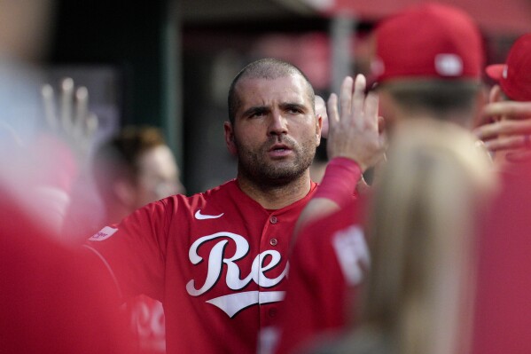 Cincinnati Reds' Joey Votto, center, is congratulated after scoring against the Cleveland Guardians during the fifth inning of a baseball game in Cincinnati, Wednesday, Aug. 16, 2023. (AP Photo/Jeff Dean)