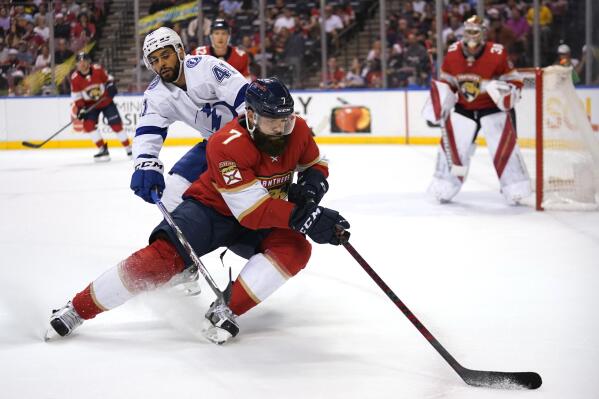 Tampa Bay Lightning left wing Pierre-Edouard Bellemare (41) and Florida Panthers defenseman Radko Gudas (7) go for the puck during the first period of an NHL hockey game, Thursday, Dec. 30, 2021, in Sunrise, Fla. (AP Photo/Lynne Sladky)