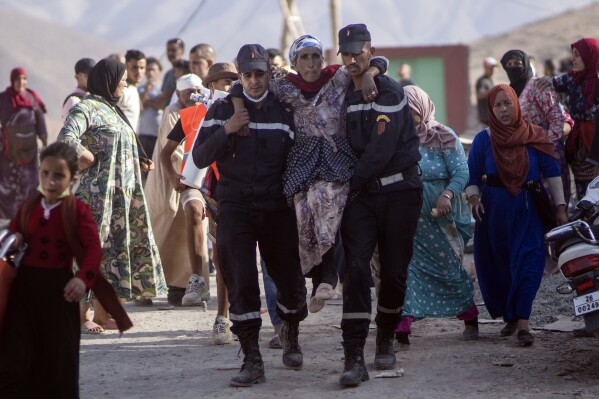 Rescue workers carry a woman who was injured by an aftershock, in the town of Imi N'tala, outside Marrakech, Morocco, Wednesday, Sept. 13, 2023. (AP Photo/Mosa'ab Elshamy)