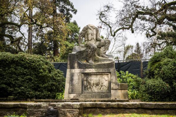 The historic statue of Charles Swanston, its head recently decapitated, stands in William Land Park on Tuesday, Dec. 27, 2022, in Sacramento, Calif. The statute of a 19th-century Northern California meat-packing magnate was beheaded earlier this week. (Hector Amezcua/The Sacramento Bee via AP)