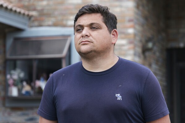 Spencer Goidel, an Equal Employment Opportunity Specialist with the Internal Revenue Service who was notified his job would be eliminated as part of the government's efficiency cuts, stands for a portrait outside his home in Boca Raton, Fla., April 16, 2025. (AP Photo/Daniel Kozin)