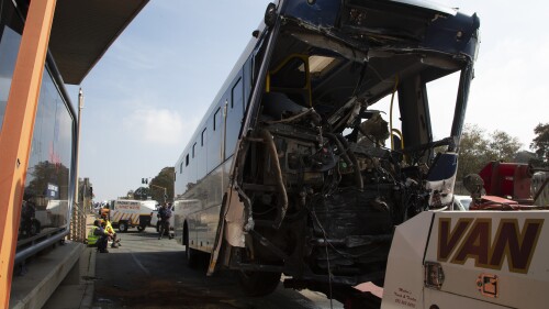 A bus is towed away after being involved in a collision at the entrance to a university in Johannesburg, Tuesday, July 25, 2023. At least 77 people were injured, five of them critically, after two buses collided at the entrance to a South African university on Tuesday, police and transport authorities said. (AP Photo/Denis Farrell)