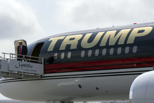 FILE - Republican presidential candidate former President Donald Trump arrives on his plane, April 10, 2024, in Atlanta. Tax Day reveals a major split in how President Joe Biden and Trump would govern: The presidential candidates have conflicting ideas about how much to reveal about their own finances and the best ways to boost the economy through tax policy. Trump says the public has no need to see his tax data and that past financial disclosures are more than sufficient. (AP Photo/Jason Allen, File)