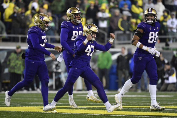 FILE -Washington placekicker Peyton Henry (47) celebrates ith punter Jack McCallister (38), tight end Quentin Moore (88) and long snapper Jaden Green (89) after making a field goal during the second half of an NCAA college football game against Oregon, Saturday, Nov. 12, 2022, in Eugene, Ore. The Big Ten has cleared the way for Oregon and Washington to apply for membership, four people familiar with the negotiations told The Associated Press., Friday, Aug. 4, 2023 (AP Photo/Andy Nelson, File)