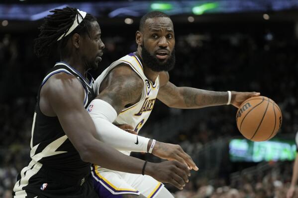 Los Angeles Lakers' LeBron James tries to get past Milwaukee Bucks' Jrue Holiday during the second half of an NBA basketball game Friday, Dec. 2, 2022, in Milwaukee. (AP Photo/Morry Gash)