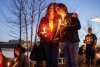 Dawn Markle and her son Evan Markle of Adair participate in a community candlelight vigil for Nex Benedict, an Oklahoma teenager who died the day after a fight in a high school bathroom in which the nonbinary student said they were a target of bullying, Sunday, Feb. 25, 2024, in Owasso, Okla. (Mike Simons/Tulsa World via AP)