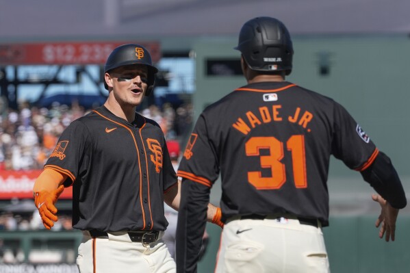 San Francisco Giants' Matt Chapman, left, celebrates with LaMonte Wade Jr. after hitting a grand slam against the Cincinnati Reds during the first inning of a baseball game Saturday, May 11, 2024, in San Francisco. (AP Photo/Godofredo A. Vásquez)