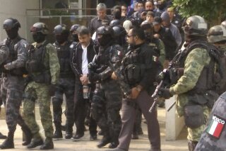 FILE - In this May 2, 2017 file photo, Damaso Lopez, a leader in Mexico's Sinaloa drug cartel, is escorted by police after his capture at an upscale apartment building in Mexico City...