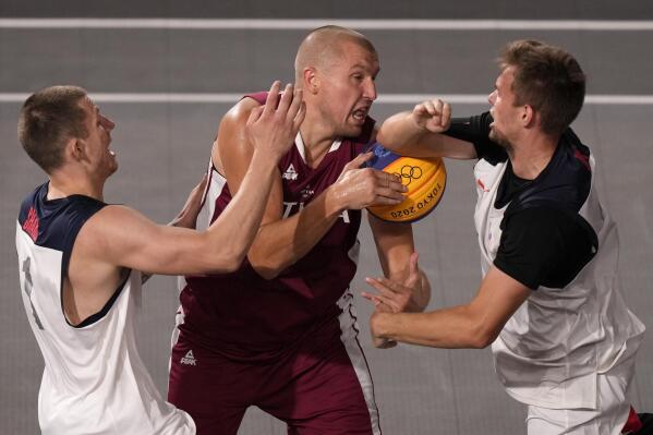 Edgars Krumins, center, of Latvia, is pressured by Stanislav Sharov (1) and Alexander Zuev, right, of the Russian Olympic Committee, during a men's 3-on-3 basketball game at the 2020 Summer Olympics, Monday, July 26, 2021, in Tokyo, Japan. (AP Photo/Charlie Riedel)