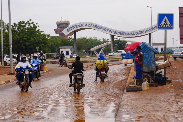 Motorcyclists ride by the entrance of the airport in Niamey, Niger, Tuesday, Aug. 8, 2023. West African heads of state have begun meeting Thursday, Aug. 10, 2023 in Abuja, Nigeria, on next steps to take after Niger's military junta defied their deadline to reinstate the deposed president. Analysts say the bloc known as ECOWAS might be running out of options as support fades for a military intervention. (AP Photo/Sam Mednick)