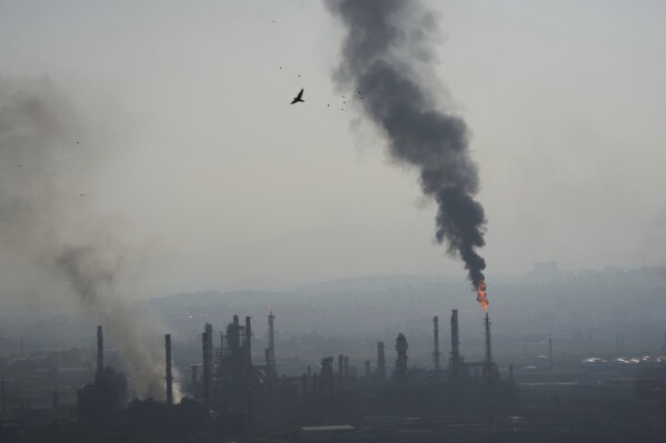 Smoke billows after an Iranian missile struck an oil refinery in Haifa, northern Israel, early Monday, June 16, 2025. (AP Photo/Ariel Schalit)