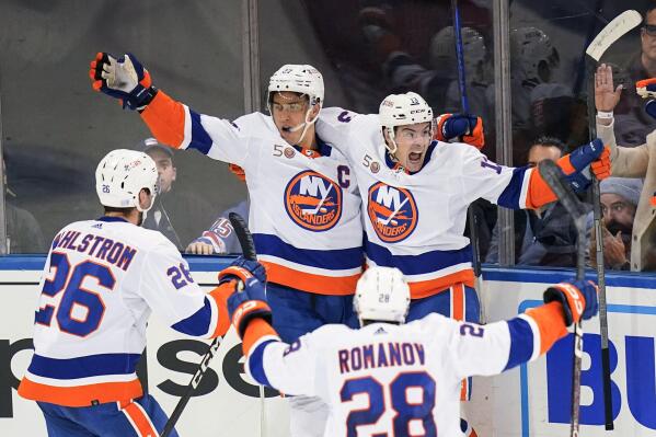 New York Islanders' Anders Lee (27) celebrates with Mathew Barzal, Oliver Wahlstrom (26) and Alexander Romanov (28) after scoring the game winning goal during the third period of an NHL hockey game against the New York Rangers Tuesday, Nov. 8, 2022, in New York. The Islanders won 4-3. (AP Photo/Frank Franklin II)