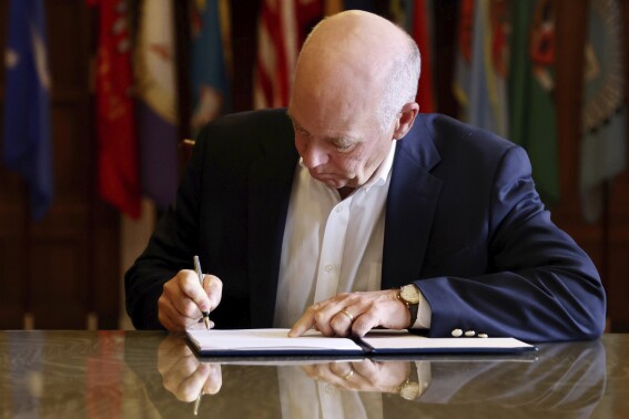 FILE - In this photo provided by the Montana Governor's Office, Republican Gov. Greg Gianforte signs a law banning TikTok in the state, Wednesday, May 17, 2023, in Helena, Mont. TikTok and five content creators who have filed lawsuits against the state arguing the ban is unconstitutional asked on judge on Wednesday, July 5, 2023, to issue a temporary injunction to block the law before it takes effect in January. ( (Garrett Turner/Montana Governor's Office via AP, File)
