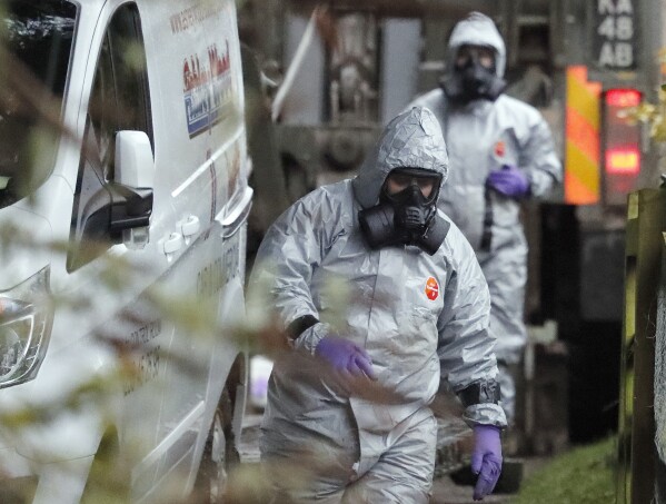 FILE - Personnel in protective gear work on a van in Winterslow, England, March 12, 2018, as investigations continue into the nerve-agent poisoning of former Russian intelligence officer Sergei Skripal and his daughter Yulia. Skripal was poisoned in Britain in 2018. He and his adult daughter fell ill in the city of Salisbury and spent weeks in critical condition. They survived, but the attack later claimed the life of a British woman and left a man and a police officer seriously ill. (AP Photo/Frank Augstein, File)