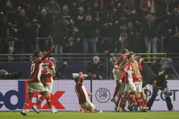 Royal Antwerp's George Ilenikhena celebrates with teammates after scoring his sides third goal during the Champions League Group H soccer match between Antwerp and Barcelona at the Bosuil stadium in Deurne, Belgium, Wednesday, Dec. 13, 2023. (AP Photo/Geert Vanden Wijngaert)
