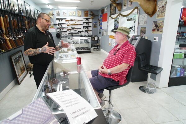 Ralph Rodriguez, left, chats with Army veteran Sidney High at his Fayetteville, N.C., pawn shop. Friday, May 9, 2025. (AP Photo/Allen G. Breed)