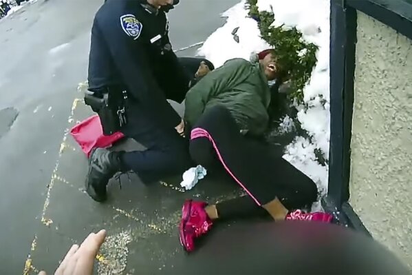 This image taken body camera video released by the Rochester, N.Y., Police Department on Friday, March 5, 2021, shows an officer struggling to subdue a woman suspected of shoplifting who tried to escape with her 3-year-old child in her arms on Feb. 22, 2021. A Rochester police officer has been placed on administrative duty after using pepper spray on the woman, authorities said Friday. (Rochester Police Department via AP)