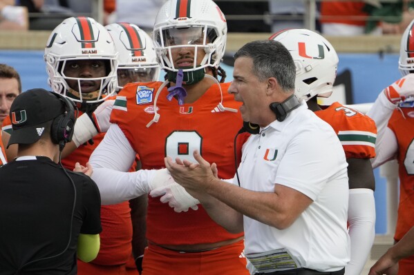 Miami head coach Mario Cristobal encourages his players as he paces the sideline during the first half of the Pop Tarts Bowl NCAA college football game against Iowa State, Saturday, Dec. 28, 2024, in Orlando, Fla. (AP Photo/John Raoux)