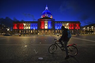 A bicyclist stops to admire the red, white and blue lights illuminating San Francisco City Hall in San Francisco, Calif., Friday, Nov. 6, 2020. Congress is beginning debate on the biggest overhaul of U.S. elections law in a generation. Legislation from Democrats would touch virtually every aspect of the electoral process — striking down hurdles to voting, curbing partisan gerrymandering and curtailing big money in politics. Republicans see those very measures as a threat that would limit the power of states to conduct elections and ultimately benefit Democrats. (Jose Carlos Fajardo/Bay Area News Group via AP, file)