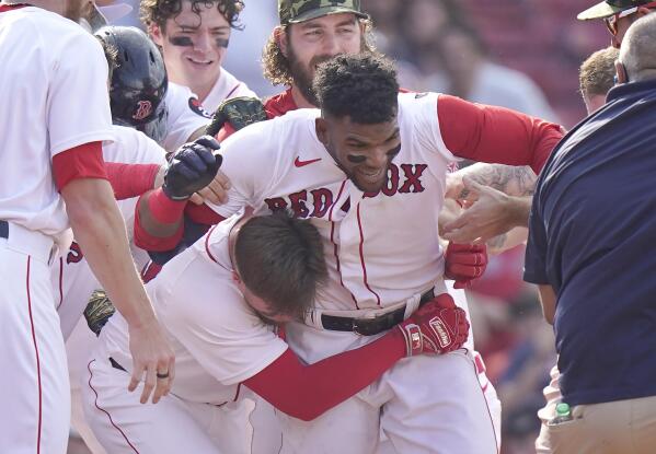 Boston Red Sox's Franchy Cordero, center, celebrates with teammates after hitting a grand slam in the tenth inning of a baseball game against the Seattle Mariners, Sunday, May 22, 2022, in Boston. The Red Sox won 8-4. (AP Photo/Steven Senne)