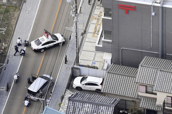 This aerial photo shows first responders take position outside the post office where a man is believed to hole up in Warabi city, Saitama prefecture, north of Tokyo, Tuesday, Oct. 31, 2023. (Kyodo News via AP)