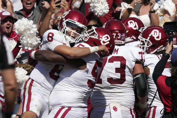 Oklahoma quarterback Dillon Gabriel (8) celebrates the game winning touchdown with teammate Caleb Shaffer (53) late in the second half of an NCAA college football game against Texas at the Cotton Bowl in Dallas, Saturday, Oct. 7, 2023. (AP Photo/LM Otero)
