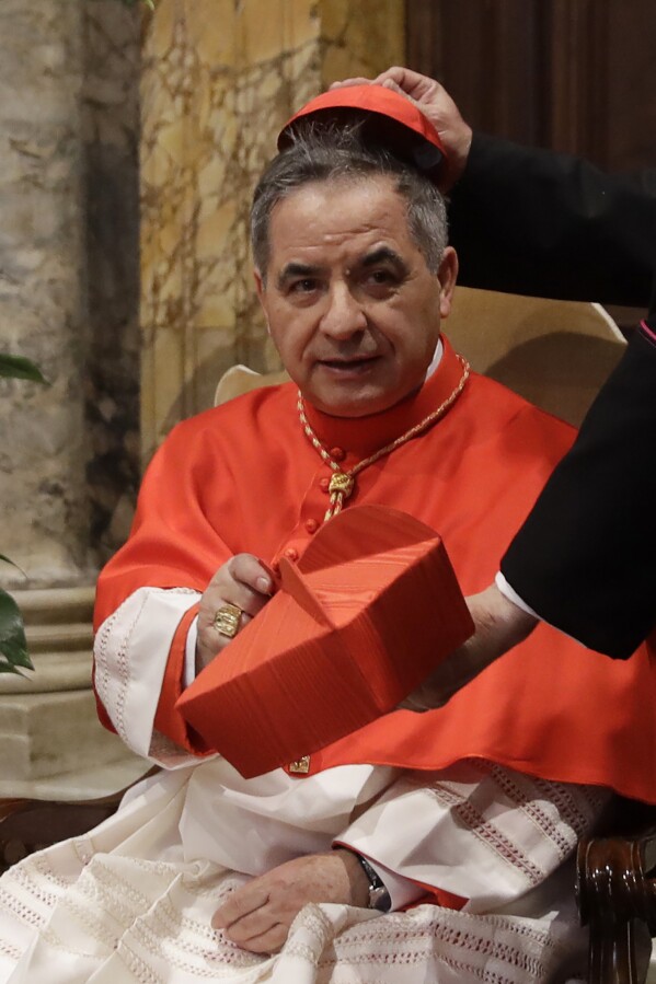 FILE - New Cardinal Giovanni Angelo Becciu changes his Beretta into a skull hat as he receives friends after Consistory at the Vatican on June 28, 2018. Lawyers for the once-powerful cardinal have accused Vatican prosecutors of "Prisoners for their completely shattered theory" In the closing arguments of a two-year trial.  Becciu is on trial with nine other people in a case focusing on the Vatican's 350 million euro investment in a London property.  (AP Photo/Alessandra Tarantino, File)