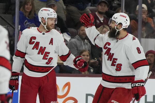 Carolina Hurricanes defenseman Jaccob Slavin (74) celebrates with defenseman Brent Burns (8) after scoring against the Arizona Coyotes in the second period during an NHL hockey game, Friday, March 3, 2023, in Tempe, Ariz. (AP Photo/Rick Scuteri)