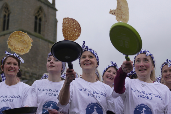Schoolchildren from local schools take part in the children's races prior to the annual Pancake race in the town of Olney, in Buckinghamshire, England, Tuesday, Feb. 13, 2024. Every year women clad in aprons and head scarves from Olney and the city of Liberal, in Kansas, USA, run their respective legs of the race with pancakes in their pans. According to legend, the Olney race started in 1445 when a harried housewife arrived at church on Shrove Tuesday still clutching her frying pan with a pancake in it. (APPhoto/Kin Cheung)